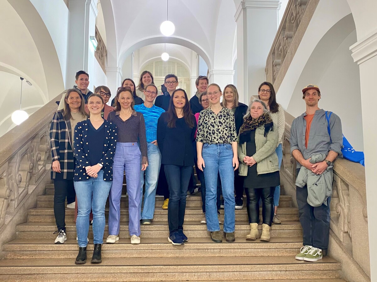 Teilnehmer:innen des Zertifikatsmoduls "Uni Innsbruck International – was, wie, warum?" posieren für ein Gruppenfoto auf der Stiege im Hauptgebäude der Universität Innsbruck.