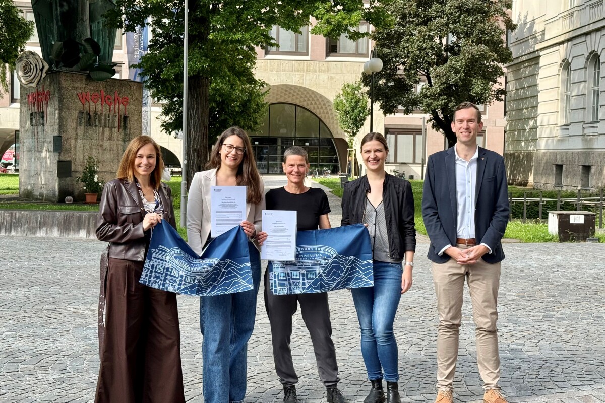 Isabella Göschl, Larissa Jenewein und Thomas Baumgartner gratulieren Jessica Spiess Stärkle und Sarah Ennemoser zum Zertifikat Internationalisierung vor dem Hauptgebäude der Universität Innsbruck.